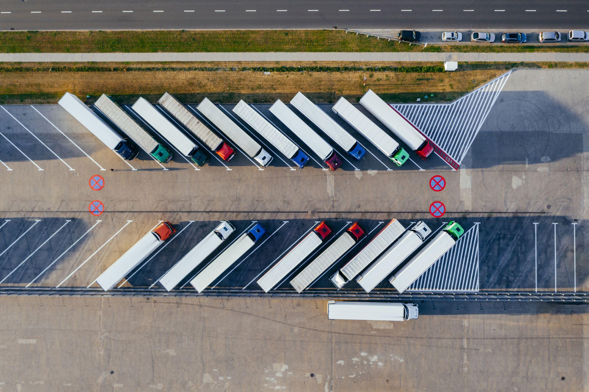 Aerial view of a fleet of trucks and trailers parked in a lot